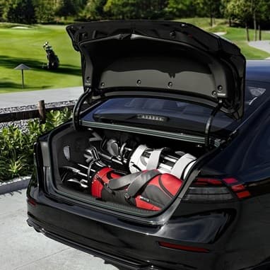 2026 Honda Accord in Crystal Black Pearl rear view parked at a golf course, with the self-opening trunk popped open with golf bags in the trunk.